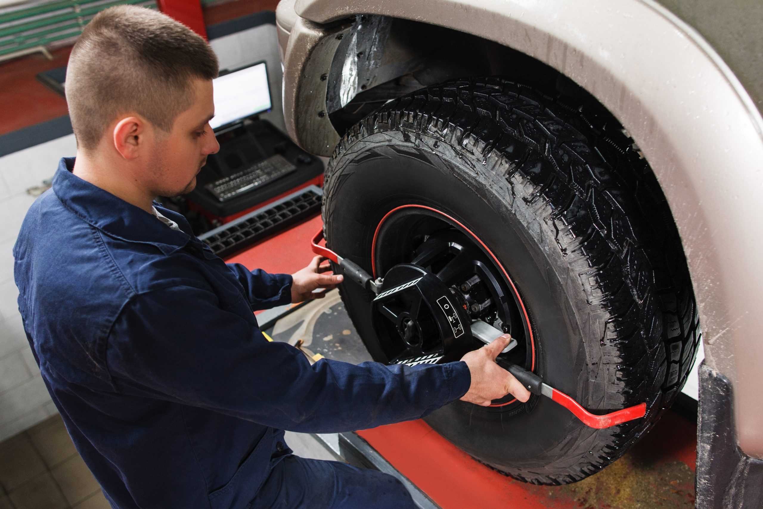 Tire alignment service on vehicle wheel.