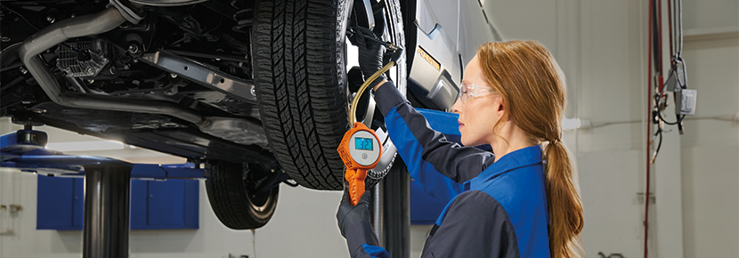 A Subaru technician checking tire pressure. | Great Lakes Subaru in Findlay OH