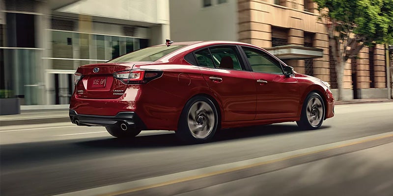 Subaru car driving on city road.