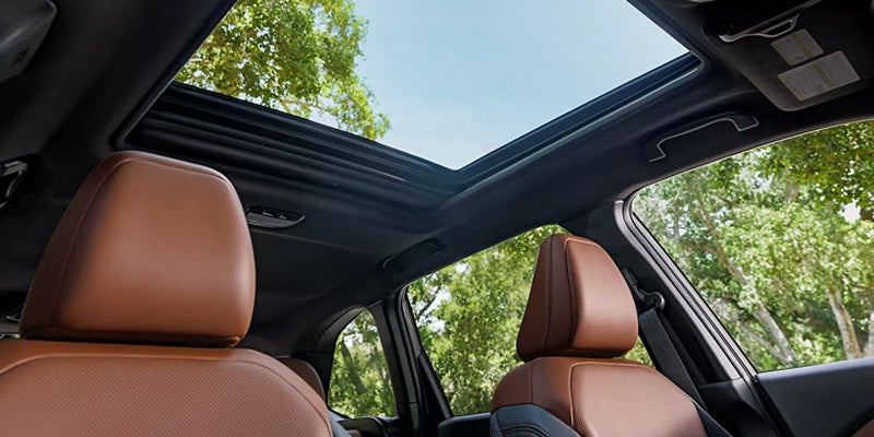 
Car interior with an open sunroof and brown leather seats